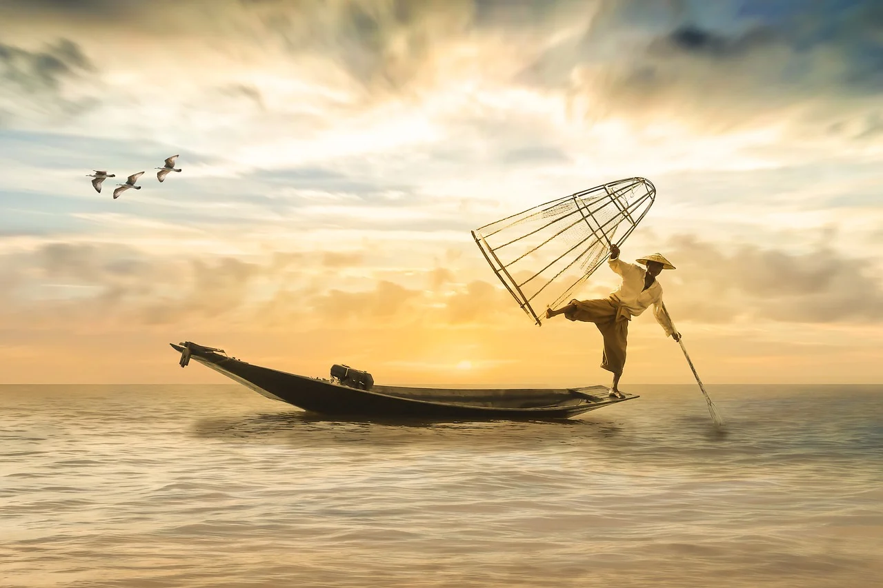 Pêcheur sur un bateau au coucher du soleil